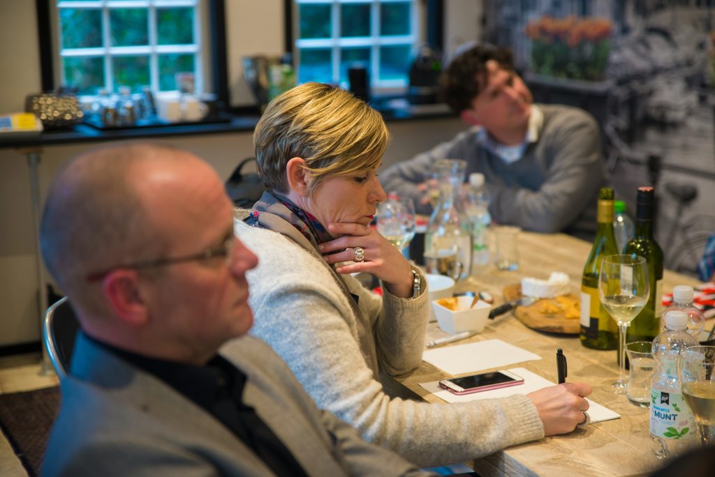 Business owners in a regional meeting analyzing the cost and impact of a cyber breach on their company.